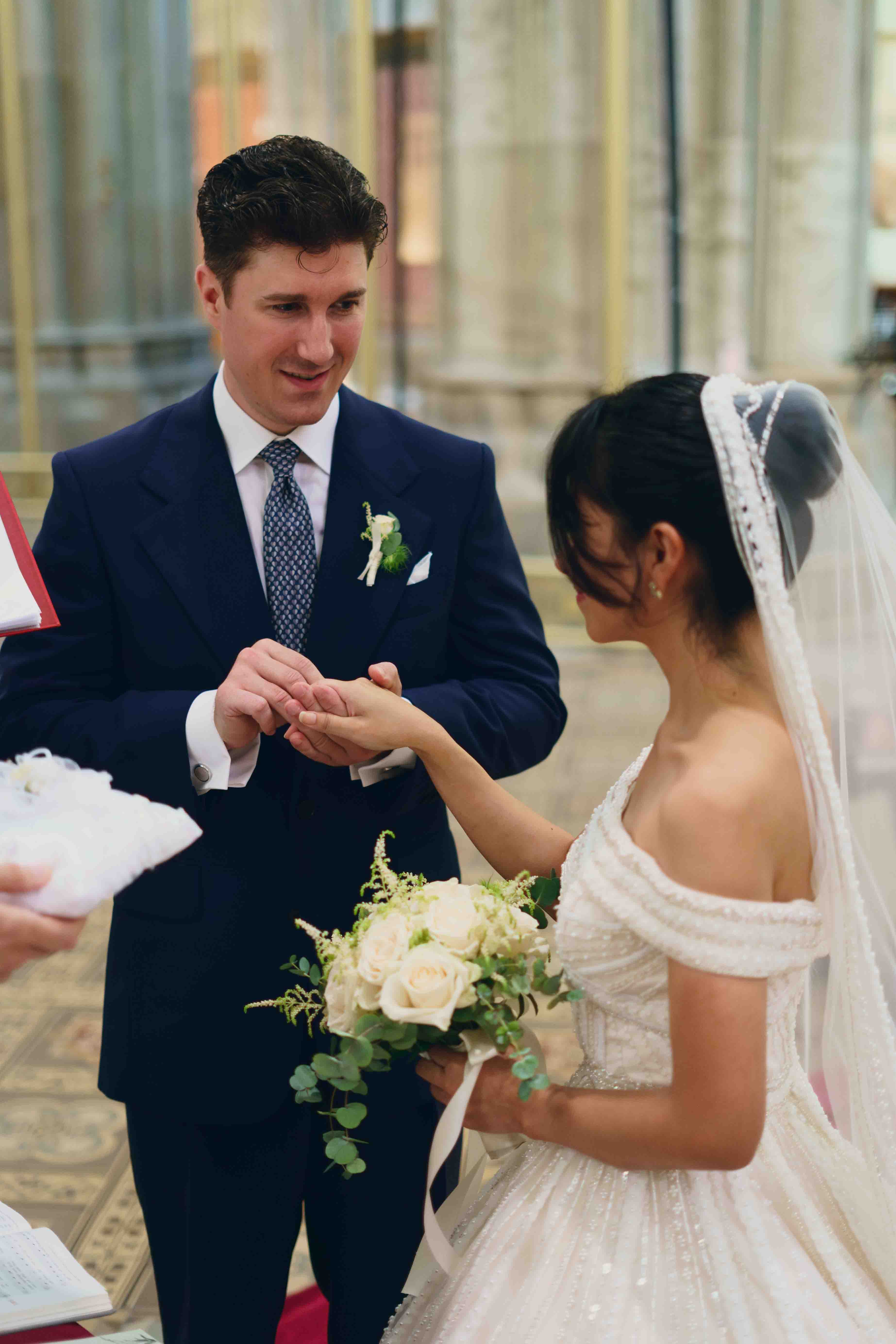 Bräutigam steckt Ehering der Braut an