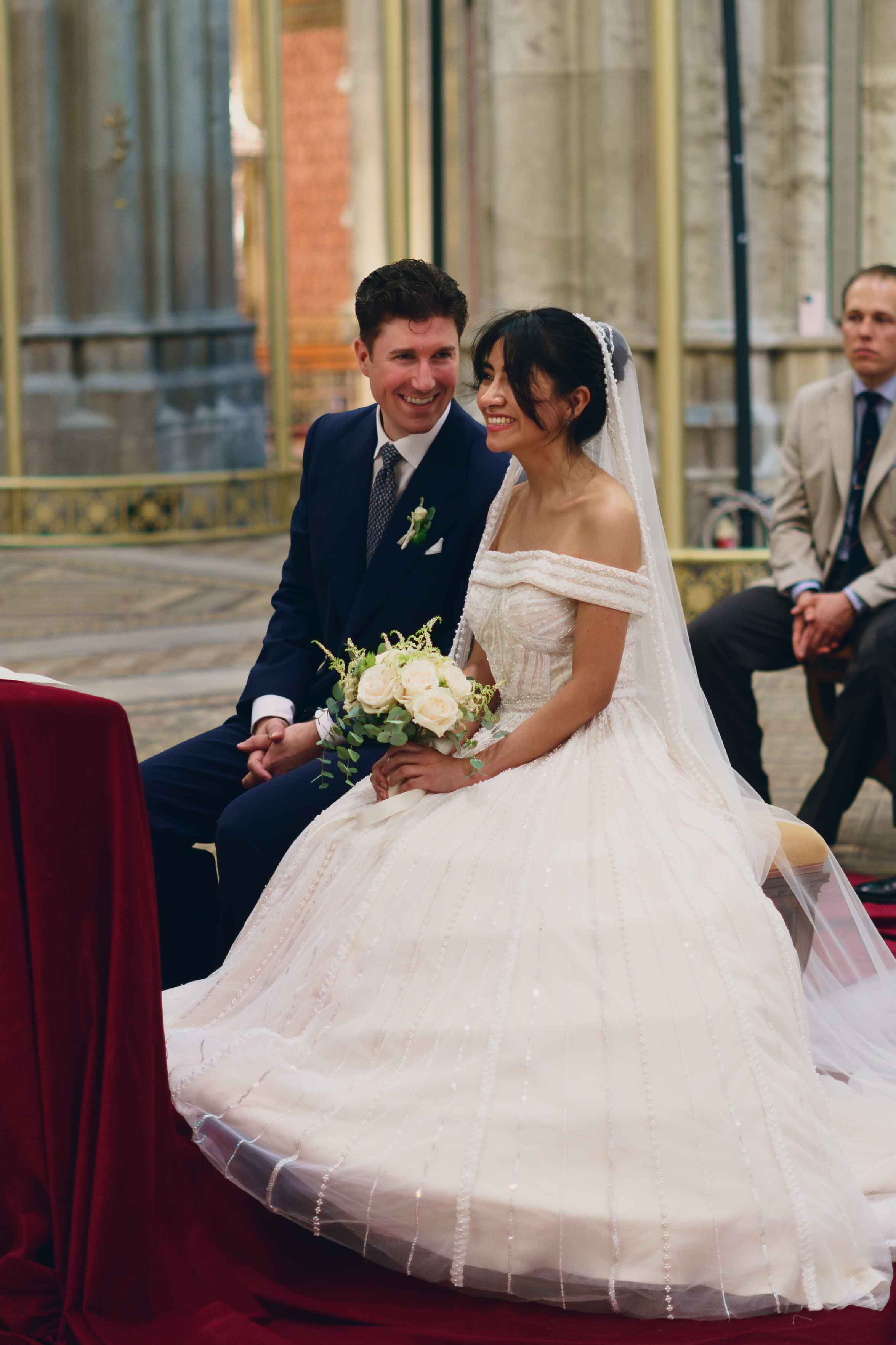 Bräutigam und Braut lächeln herzlich am Altar