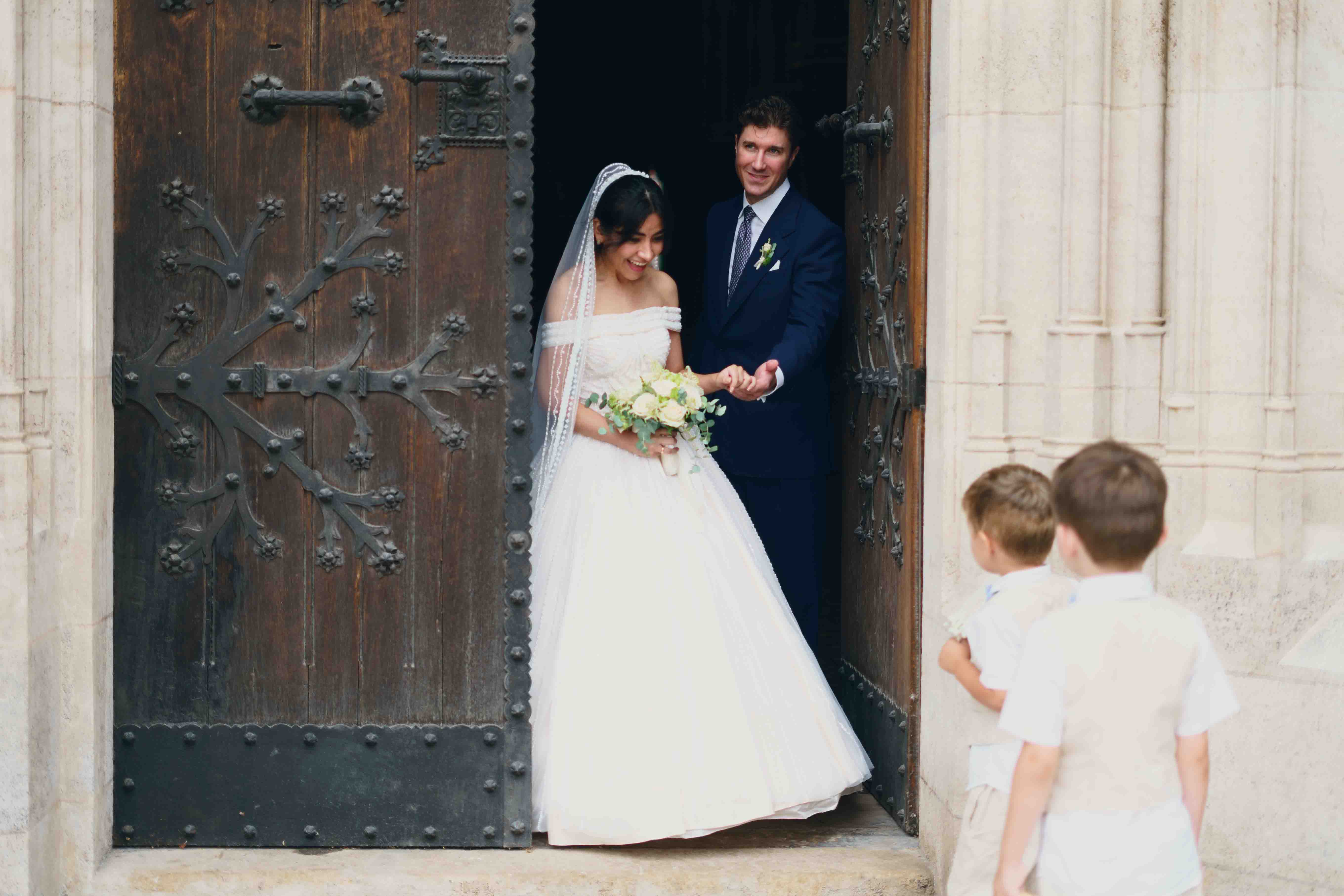 Braut und Bräutigam gehen lachend aus der Kirche